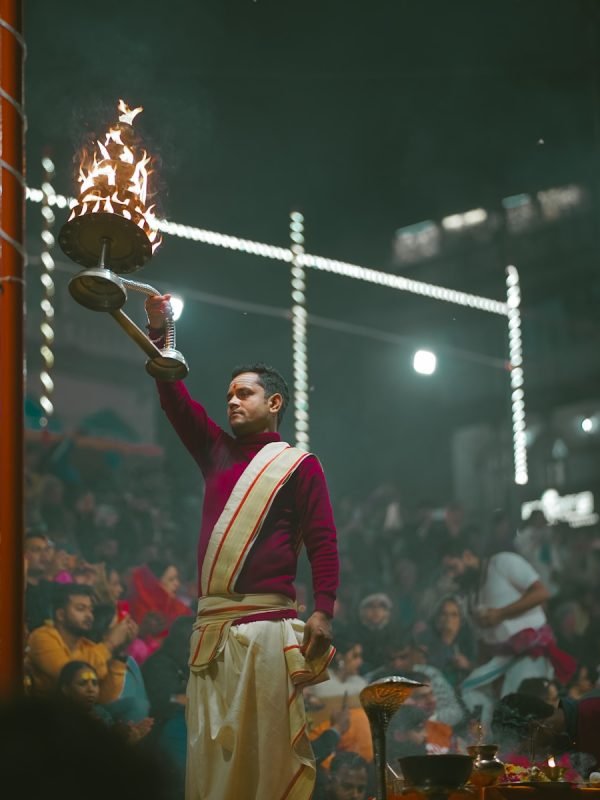 a man in a red and white outfit holding a basket of fire